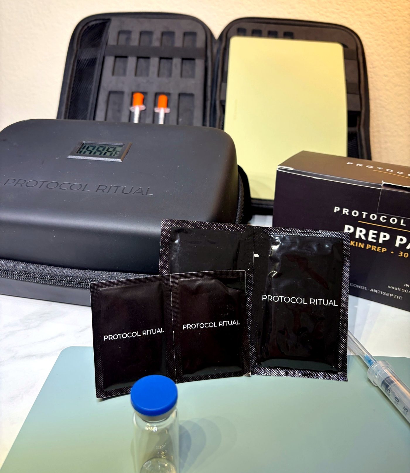 Protocol Ritual prep pads, travel case and box together on a slate mat