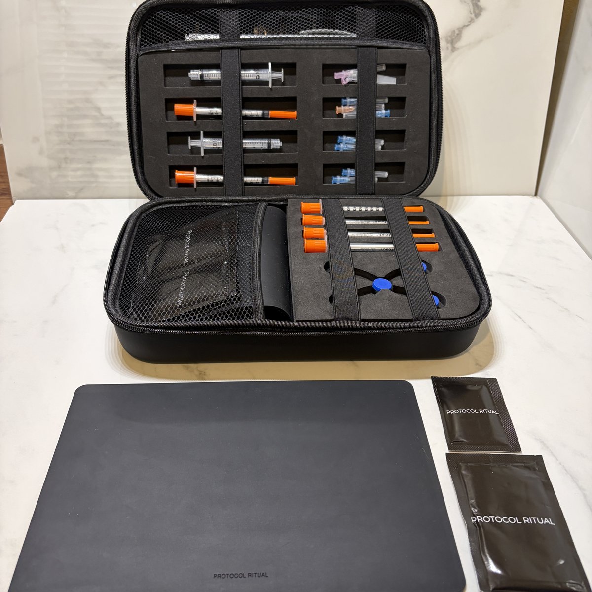 Protocol Ritual Kit fully loaded with syringes, needles, and vial slots, mat and pads in front